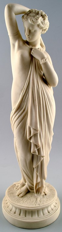 Antik stor biscuit figur af semi-nøgen kvinde i klassisk stil.
