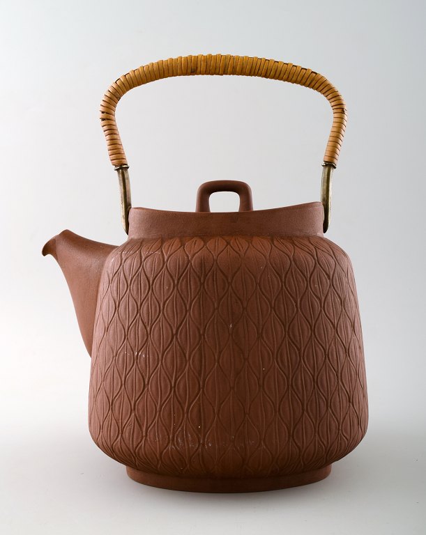 Jens Quistgaard: Teapot in fired chamotte clay with handle of cane.
Stamped Palshus, Denmark, JHQ. 1950.