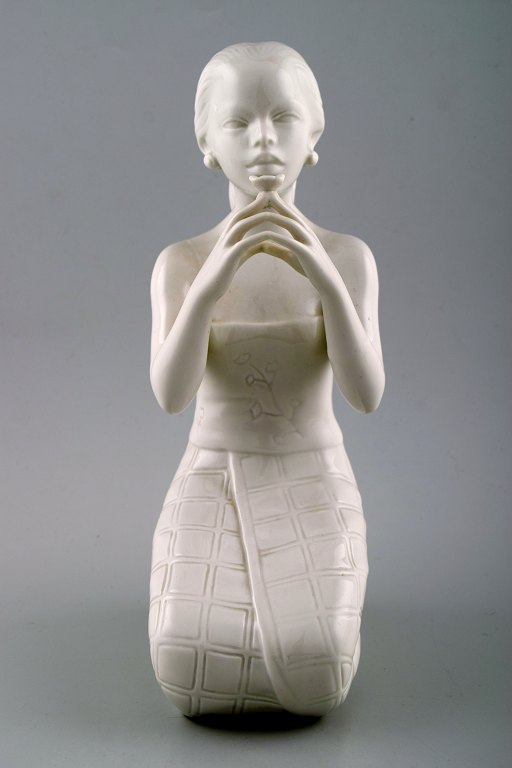 Harald Salomon for Rörstrand, white glazed figure of Balinese holding flower in 
her hand.