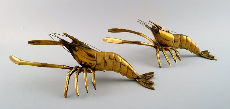 Two brass table decorations in the shape of lobsters.
