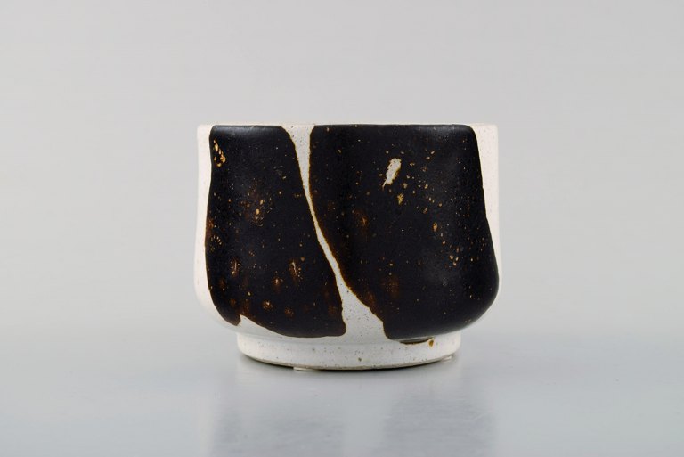 Lise Honoré, dansk keramiker. Lille skål i keramik med glasur i brune nuancer på 
lys baggrund. Sent 1900-tallet.
