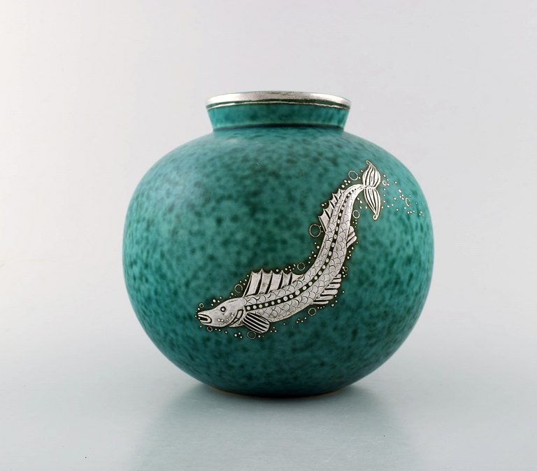 Wilhelm Kåge, Gustavsberg, kuglerund hånddrejet art deco vase i keramik 
dekoreret med fisk i sølvindlæg.