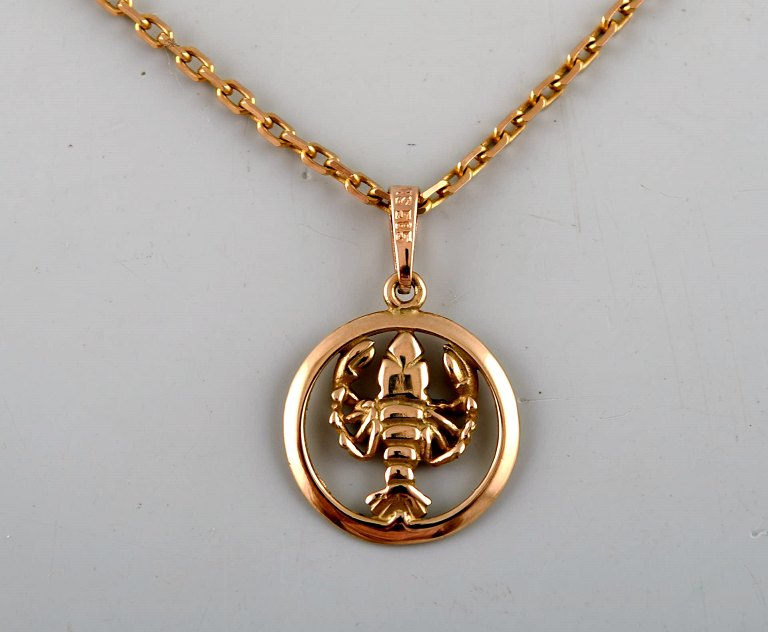 Swedish goldsmith. Necklace with pendant in 14 carat gold. Zodiac sign cancer. 
Mid 20th century.
