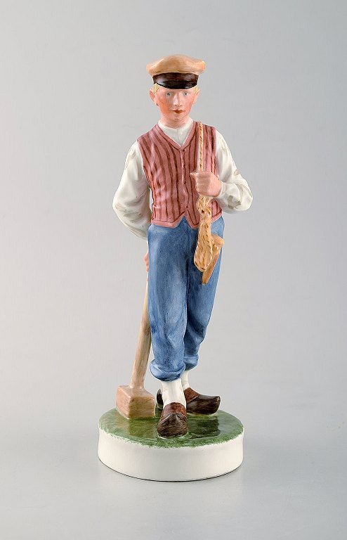 Royal Copenhagen porcelain figurine in high quality over glaze. Farmer / 
Guardian boy with lumber hammer. Model Number: 620.