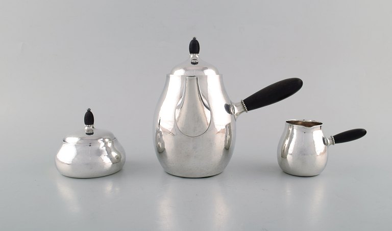 Georg Jensen art nouveau coffee pot with sugar bowl and creamer in sterling 
silver with handle and knob in ebony. Model Number 80A. Designed in 1915.
