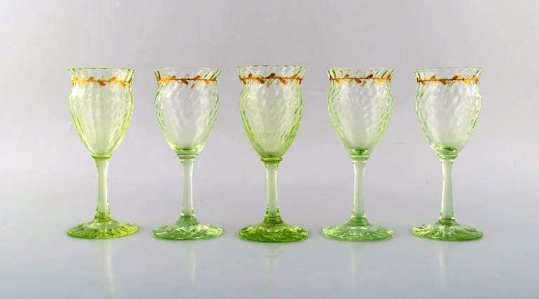 Emile Gallé (1846-1904). Fem tidlige og sjældne vinglas i mundblæst lysegrønt 
kunstglas med håndmalede guldekorationer i form af blade. Museumskvalitet, 
1870/80