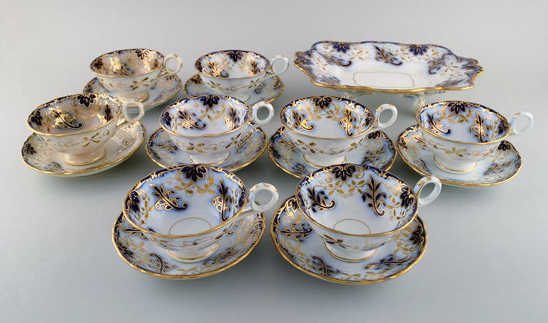 Davenport, Longport Staffordshire. Antique tea service for eight people in 
hand-painted porcelain. Purple flowers and gold decoration. Early 20th century.
