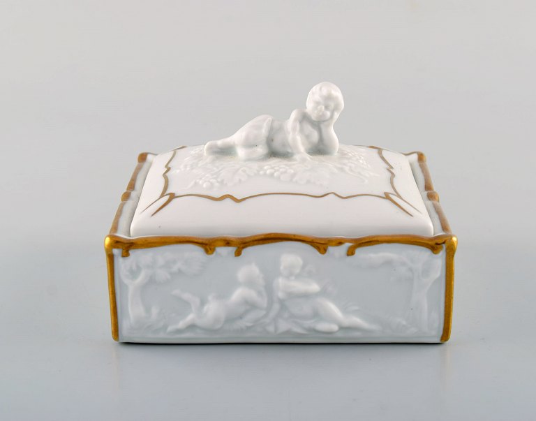 Capodimonte, Italy. Gilded porcelain lidded box decorated with romantic scenes. 
Early 20th century.
