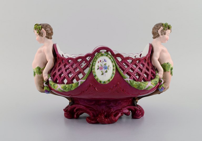 Large antique Meissen centrepiece in openwork hand-painted porcelain decorated 
with fauns. Approx. 1910
