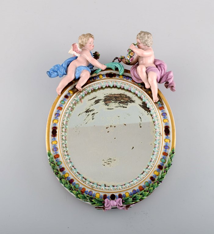 Antique Meissen porcelain mirror with original glass. Decorated with angels and 
repousse flowers. 19th century.
