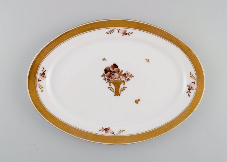 Oval Royal Copenhagen Golden Basket serving dish in porcelain with flowers and 
gold decoration. Model number 595/9008. Early 20th century.
