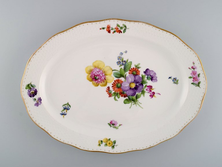 Royal Copenhagen Saxon Flower special version. Large and rare serving dish with 
hand-painted flowers and gold decoration. Approx. 1900.
