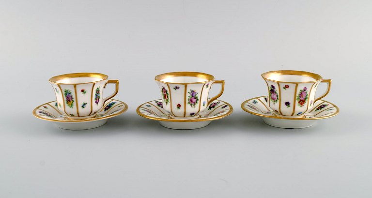 Tre Royal Copenhagen Henriette mokka kopper med underkopper i håndmalet porcelæn 
med blomster og gulddekoration. Tidligt 1900-tallet. 
