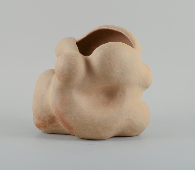 Christina Muff, dansk samtidskeramiker (f. 1971).
Unique organically shaped vase in light golden stoneware clay. Clear glaze on 
the inside.
