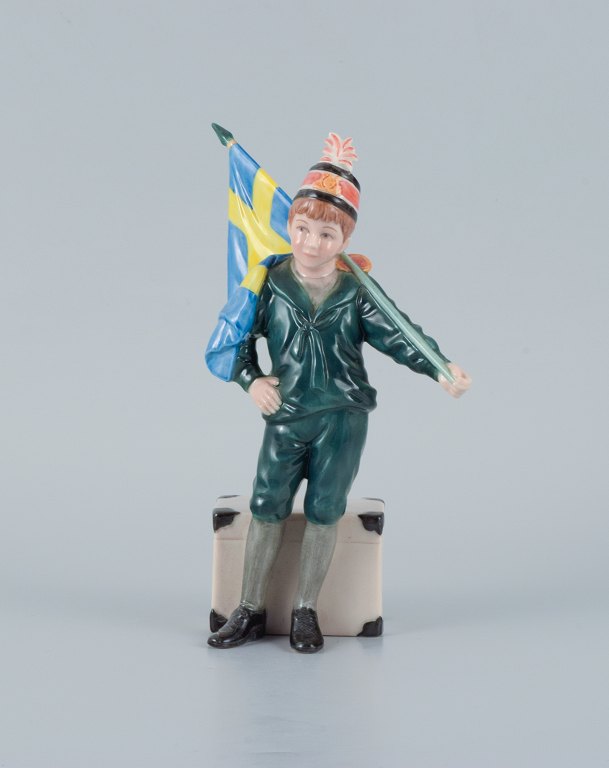 Carl Larsson Pontus for Royal Copenhagen, håndmalet porcelænsfigur i overglasur, 
svensk fanebærer-dreng i grønne klæder.