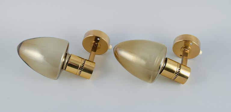 Hans Agne Jakobsson, Sweden, a pair of wall sconces in brass and smoked glass.
