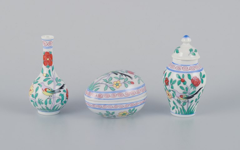 Herend, Hungary, three pieces of porcelain, consisting of a lidded jug, small 
vase, and egg-shaped lidded jar, hand-painted with flowers and birds.