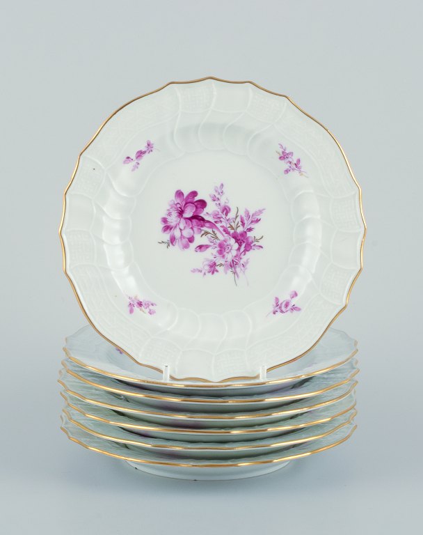 Meissen, Germany. A set of seven porcelain plates hand-painted with purple 
flower decoration and gold trim.