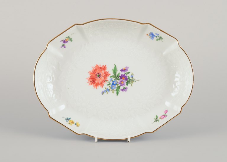 Meissen, Germany. Oval porcelain bowl hand-painted with polychrome flowers. 
Flower garlands in relief. Gold rim.