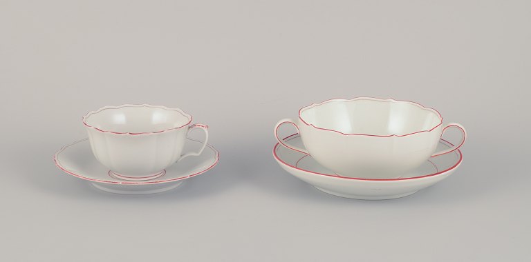 Meissen, Germany. Tea cup and bouillon cup with saucers. Decorated with coral 
red and gold-colored trim. Art Deco.