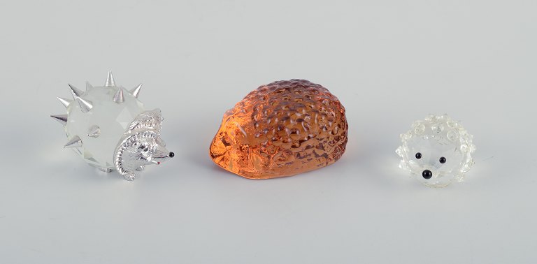 Three hedgehogs in art glass and metal.