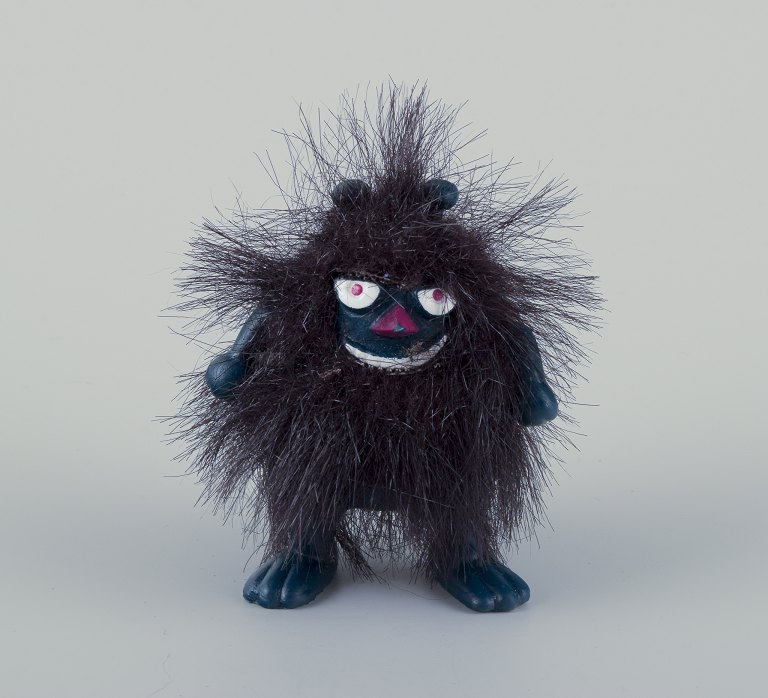 Martinex, Finland. "Stinky" Mummi figur af mørkeblåtplast beklædt med sort hår.