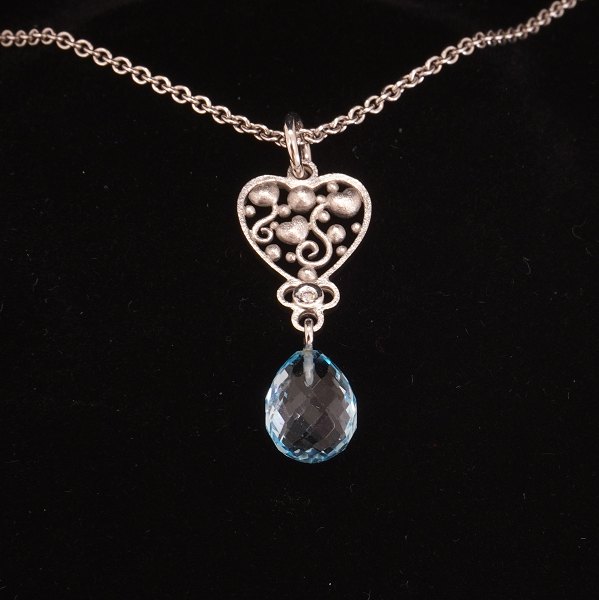 Ole Lynggaard Tornerose halskæde og vedhæng i 14kt hvidguld prydet med en diamant og topas. Mål vedhæng: 35x15mm. Halskæde L: 44cm
